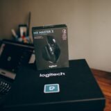 Cutia unui telefon nou, încă sigilată, așezată pe un birou lângă o foaie cu specificații tehnice