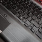 Lacăt metalic mic așezat pe tastatura unui laptop, simbolizând protejarea conturilor online