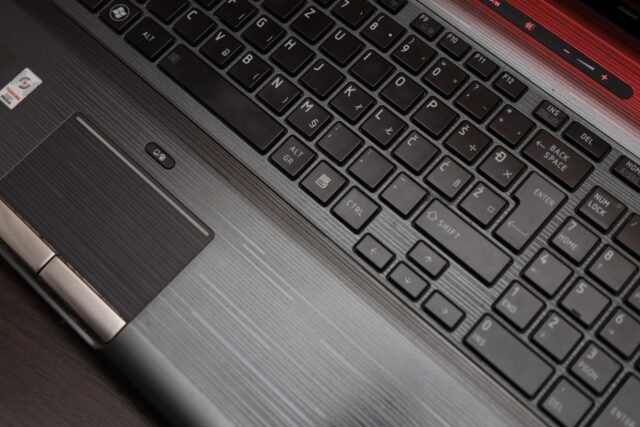 Lacăt metalic mic așezat pe tastatura unui laptop, simbolizând protejarea conturilor online