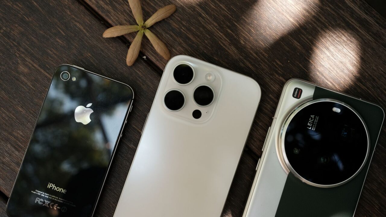 Mai multe smartphone-uri de dimensiuni diferite așezate unul lângă altul pe o masă din lemn